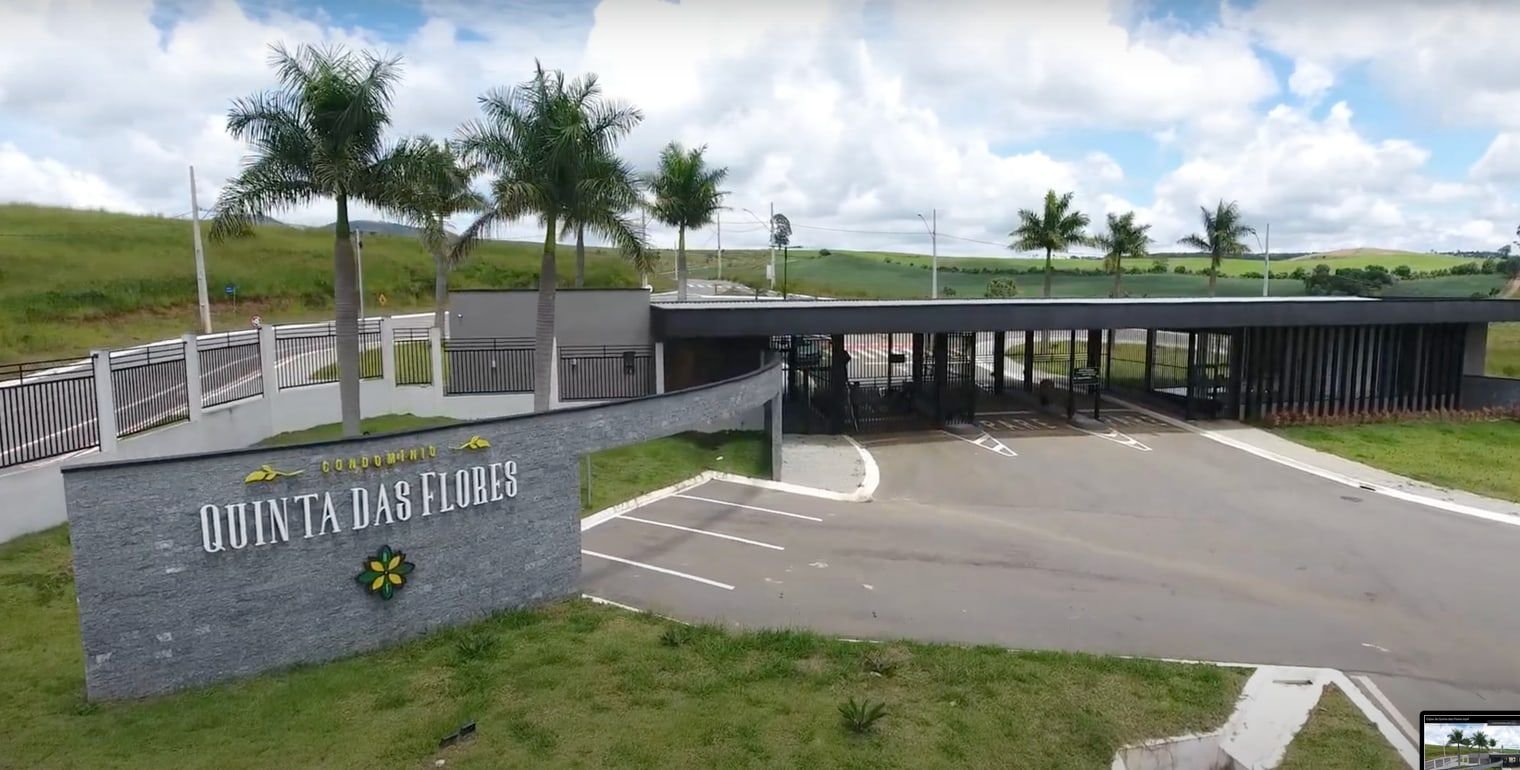 Portaria do Condomínio Quinta das Flores, em Andradas, com palmeiras na entrada